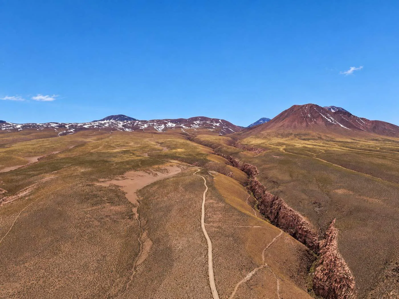 Aerial view of a ravine crossing the high desert towards the volcanoes